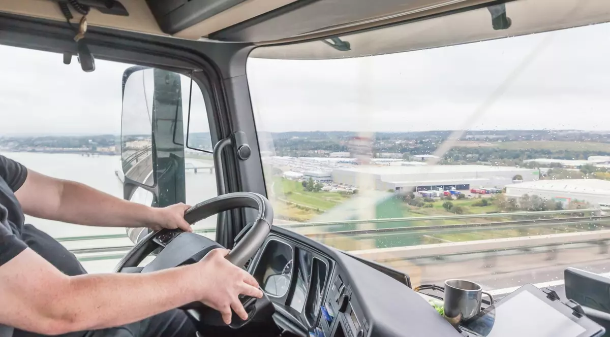 Imagine cu un bărbat care ține mâinile pe volan.