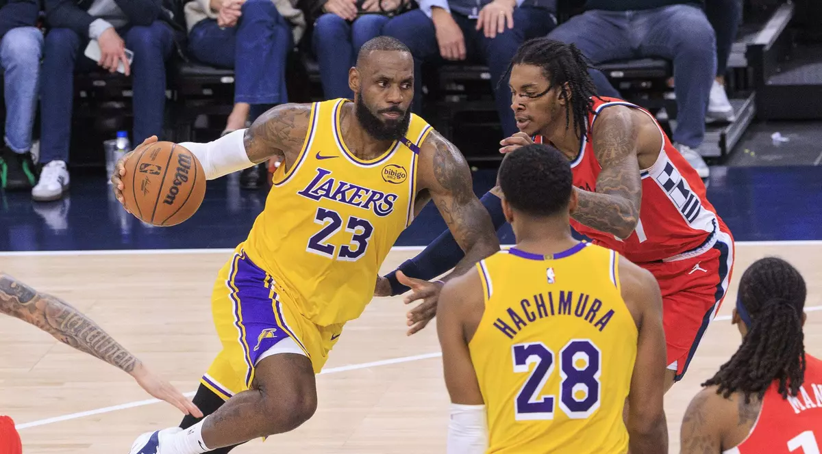 Lebron James de la Los Angeles Lakers îl driblează pe Kevin Porter de la Los Angeles Clippers, în timpul unui meci din NBA.