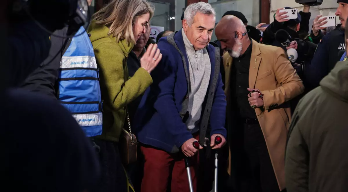 Călin Georgescu în cârje pe treptele de la Parchetul General, cu Cristela Georgescu lângă el.