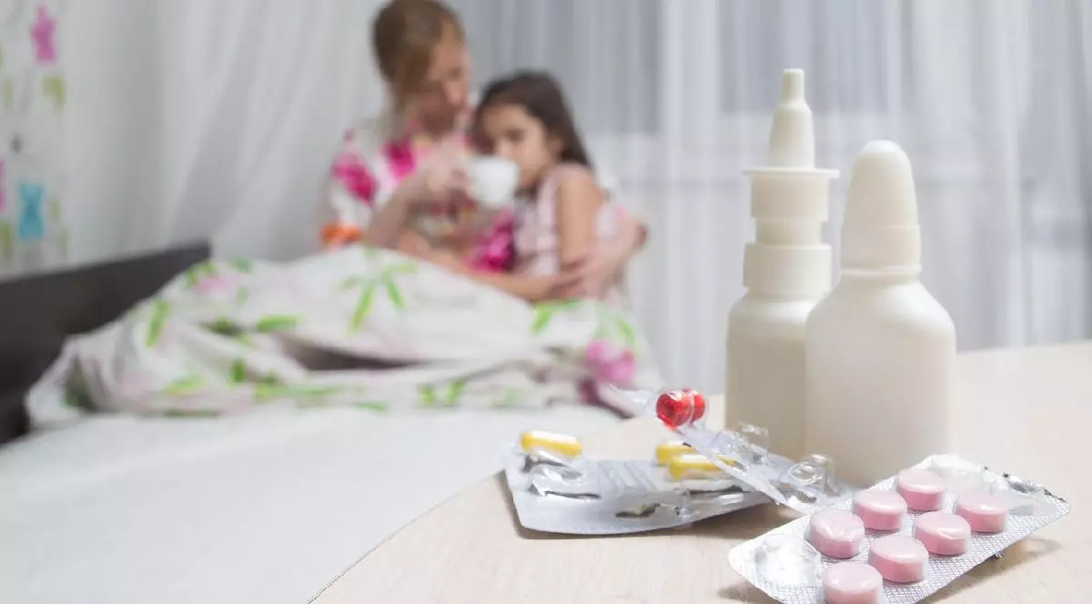 mama si un copil bolnav de gripa, pastile, picaturi de nas