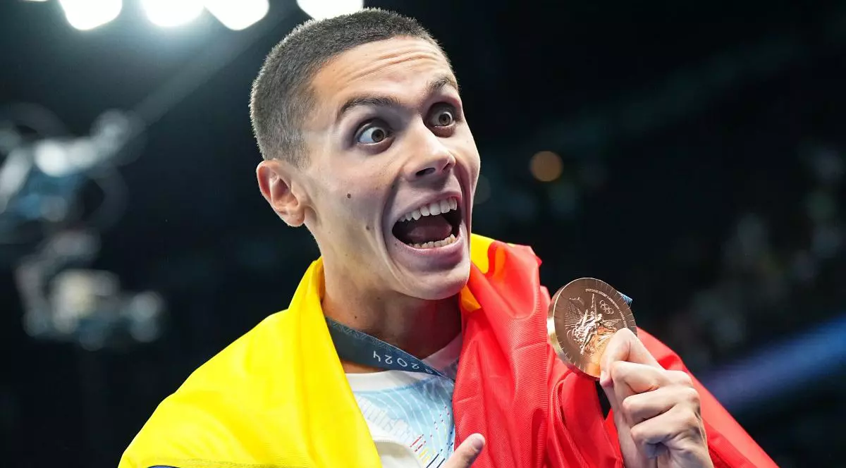 31 iulie 2024, Franța, Paris: Jocurile Olimpice, Paris 2024, 100 m liber, masculin, finală, locul trei, David Popovici din România sărbătorește cu medalia de bronz