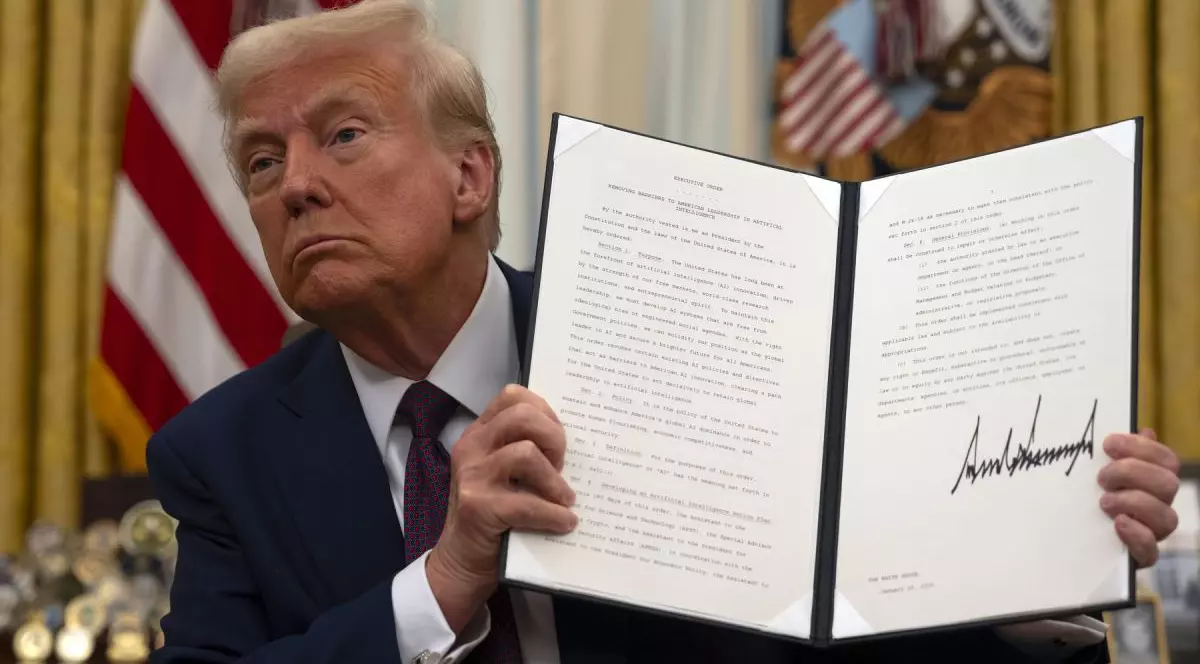 Donald Trump, în Biroul Oval de la Casa Albă, în timp ce arată un ordin executiv semnat