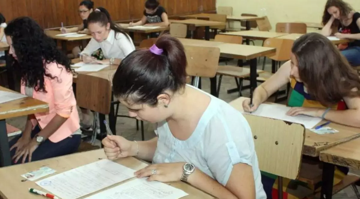 Elevi de liceu în bănci în timp ce completează un test