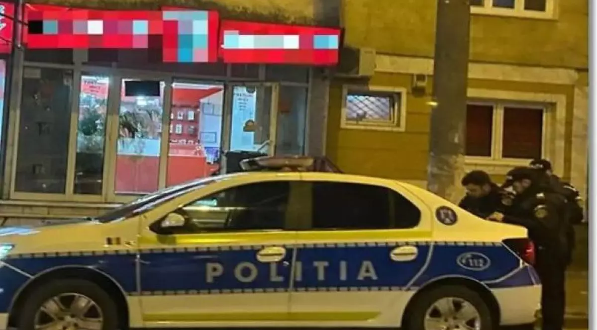 Agenții de poliție, alături de mașina de serviciu, la puțin timp după ce casa de amanet a fost jefuită