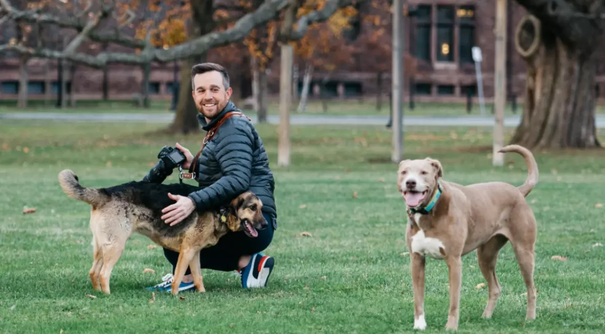 John Fabiano și doi câini, la iarbă verde