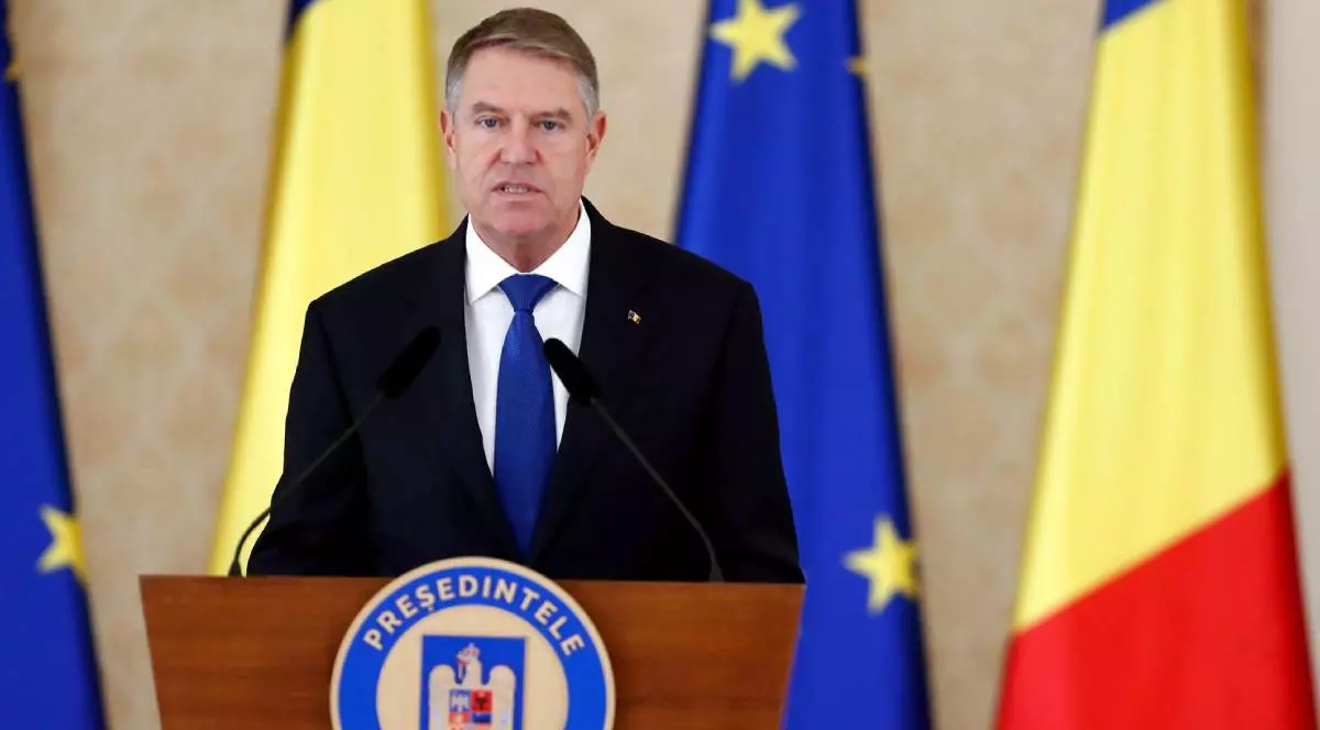 presedintele romaniei klaus iohannis in timpul unui discurs la pupitru, in spatele lui sunt drapelul romaniei si drapelul UE