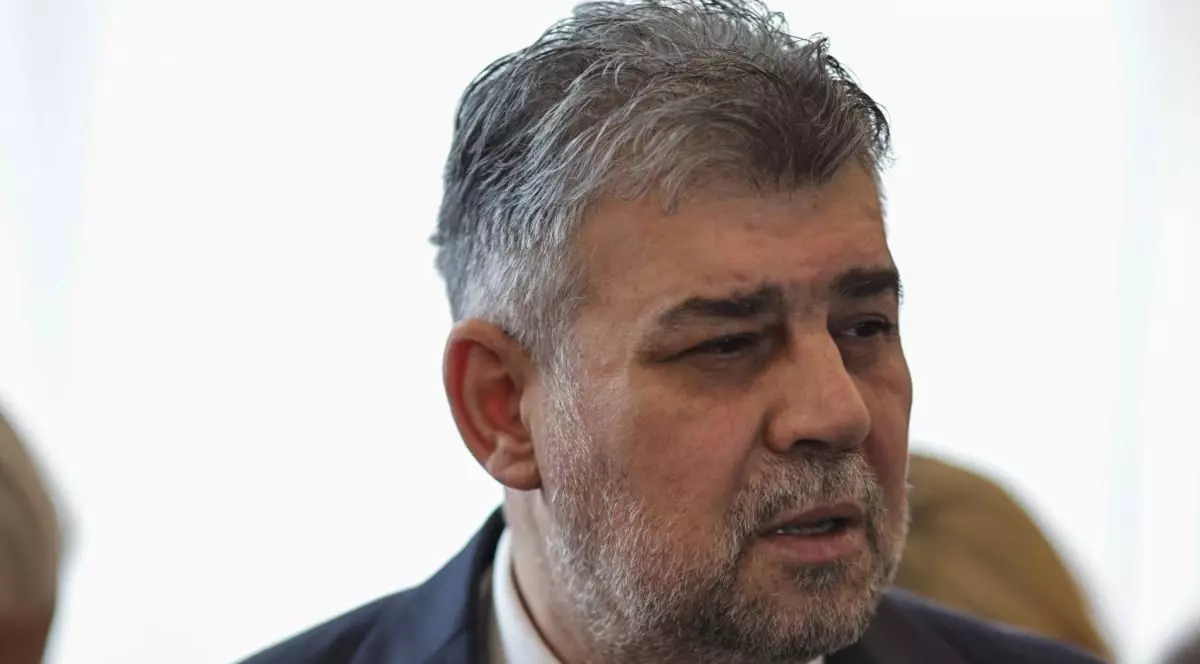 Premierul Marcel Ciolacu, pe un fundal alb, înainte de ședința de guvern unde se va adopta mecanismul de actualizare al salariului minim