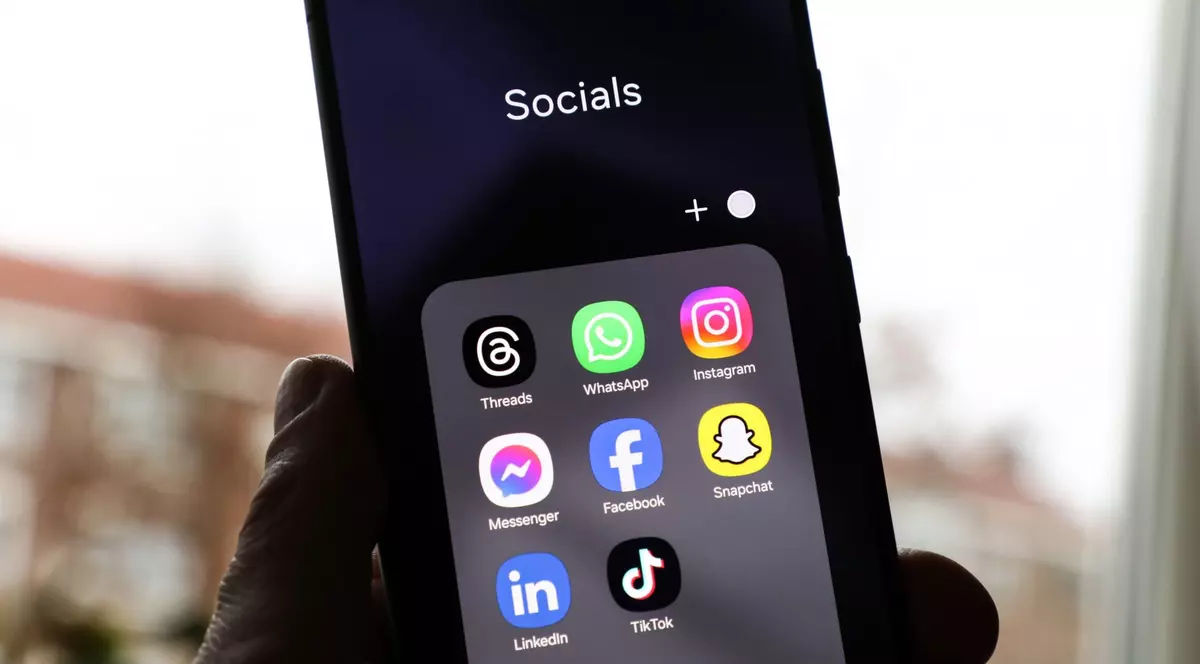 Un folder cu diverse aplicații de rețele sociale, deschis pe un telefon.