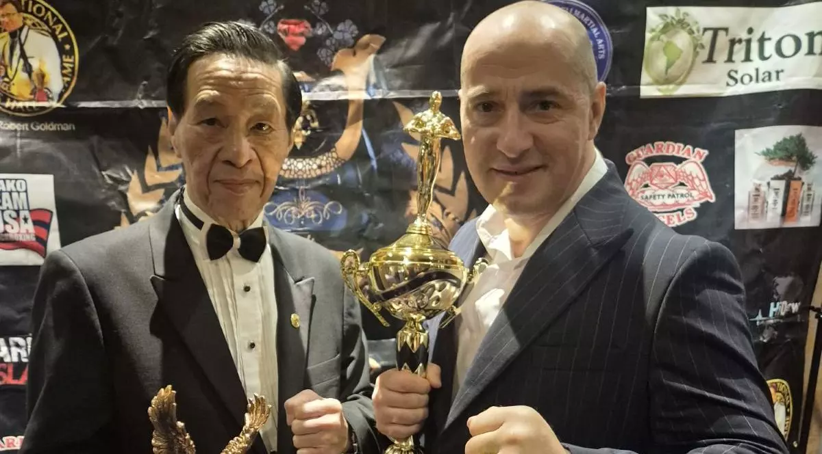 Ovidiu Sfetcu, alături de unul dintre organizatori, după ce a fost premiat. În mână ține trofeul pe care l-a câștigat