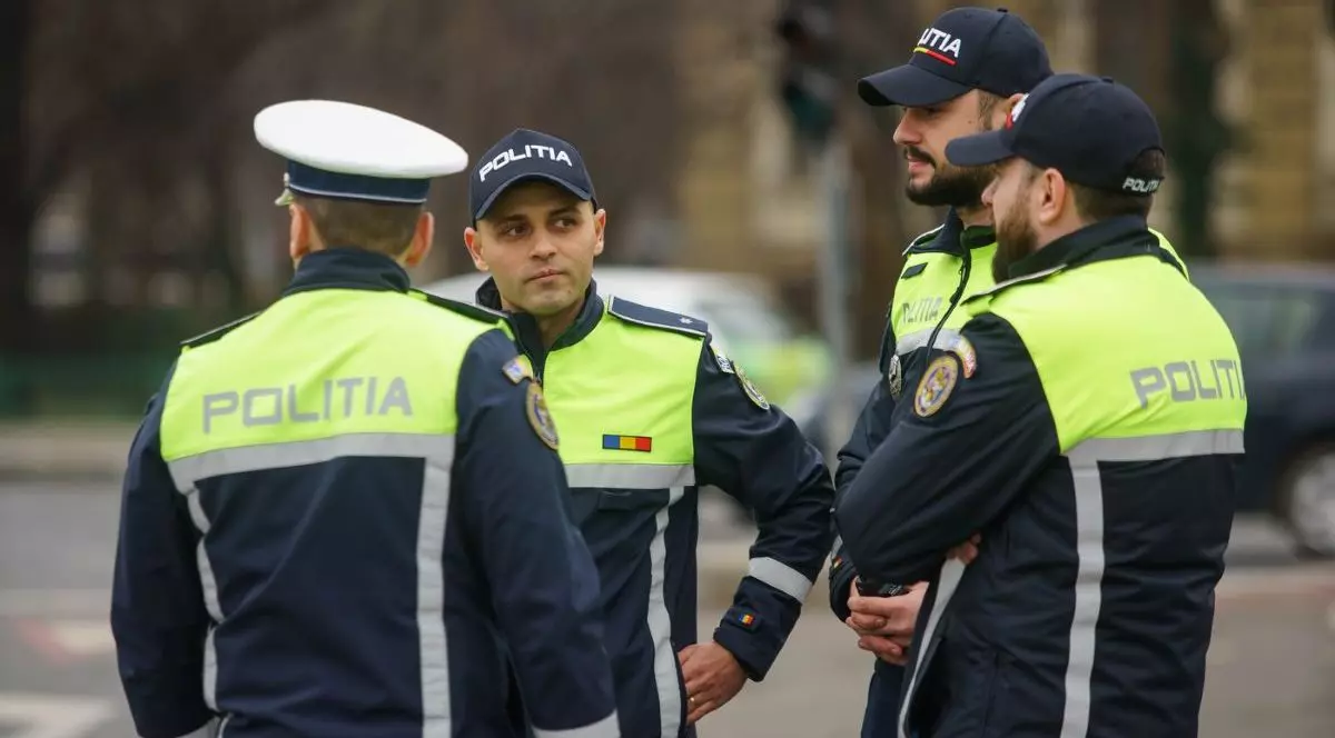 Patru polițiști de la Brigada Rutieră discută în plină stradă., Toți sunt în uniformă și au capetele acoperite