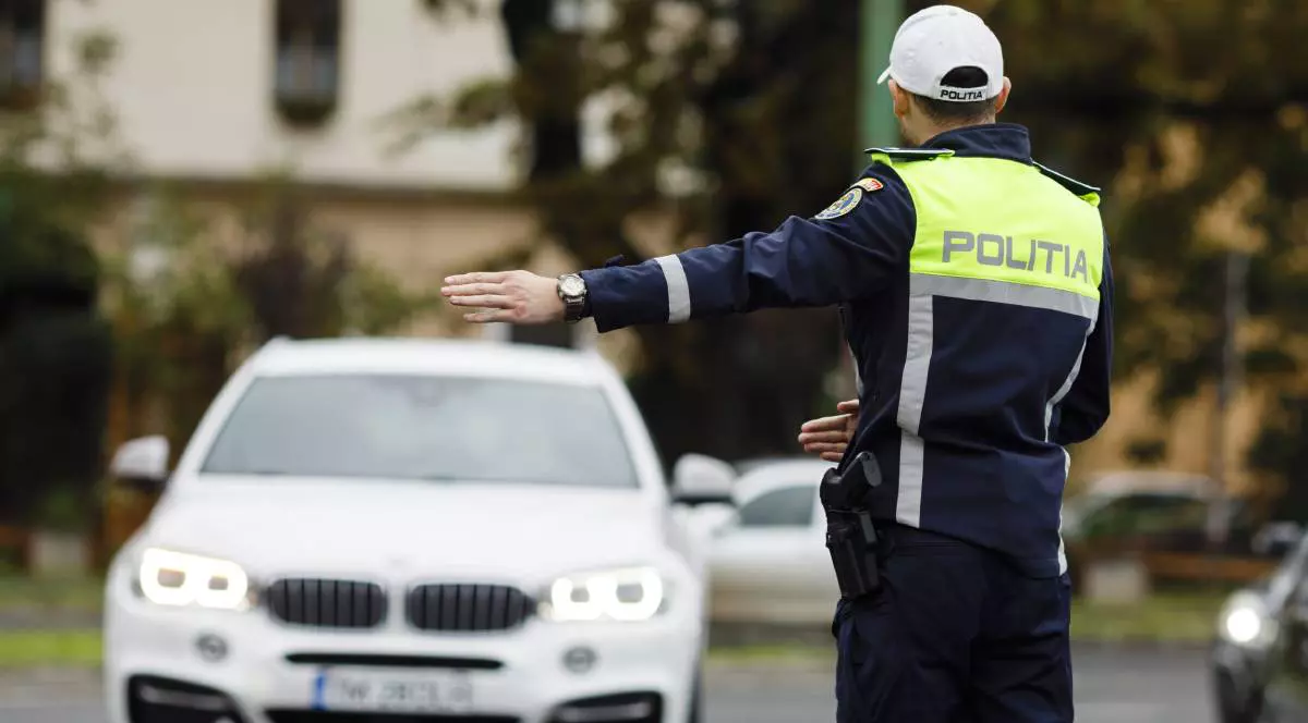politist imbracat in uniforma in timp ce opreste o masina in trafic