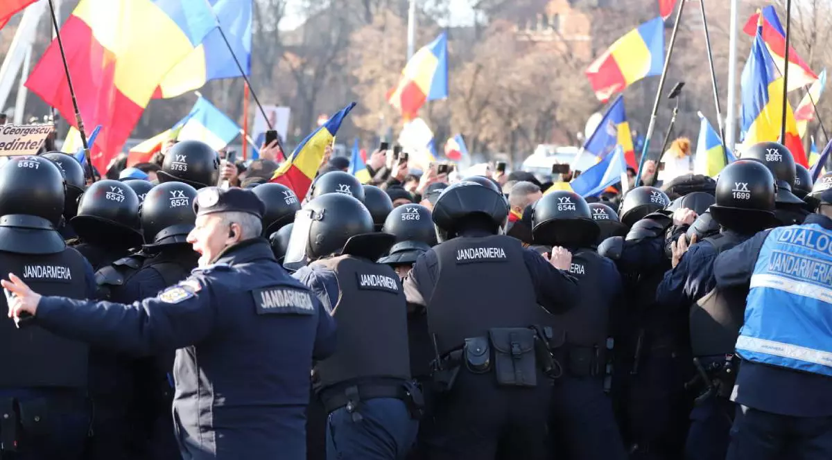 oameni in timpul unui protest tinuti de jandarmi in timp ce au daramat gardurile limita