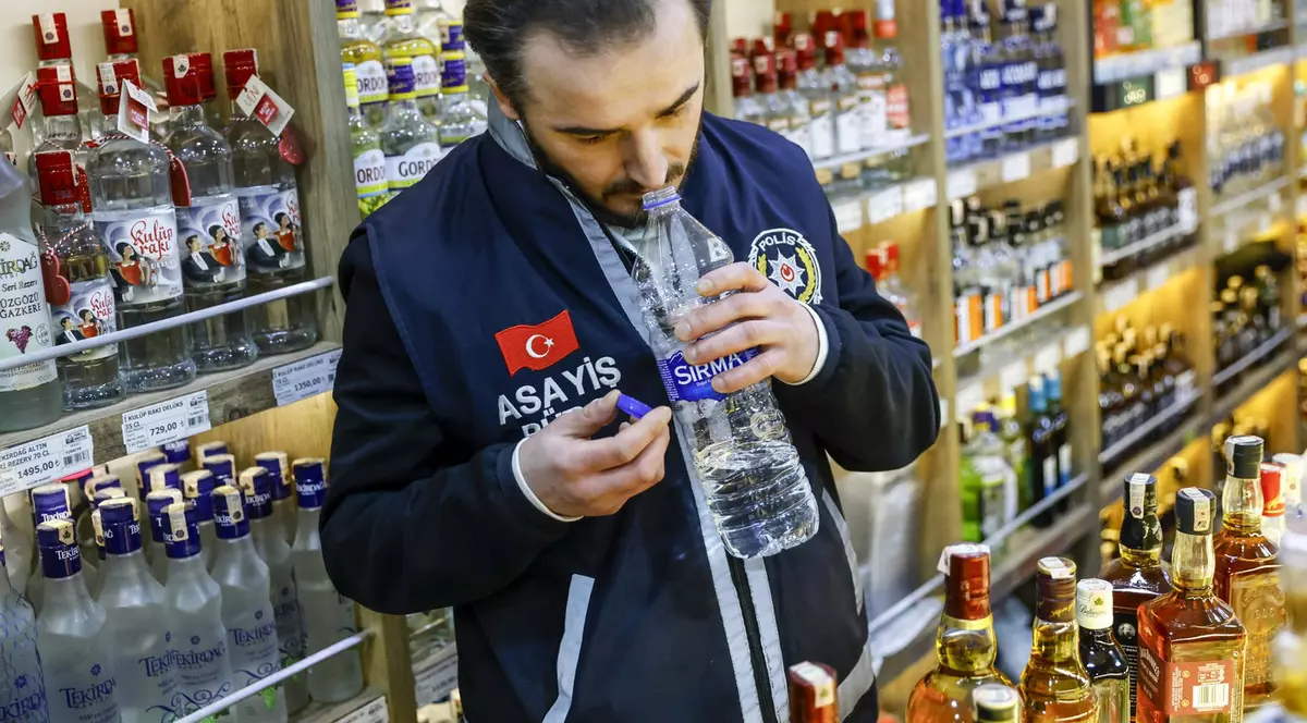 Un ofițer de poliție turc inspectează alcool vândut într-un magazin din Istanbul Foto: Profimedia