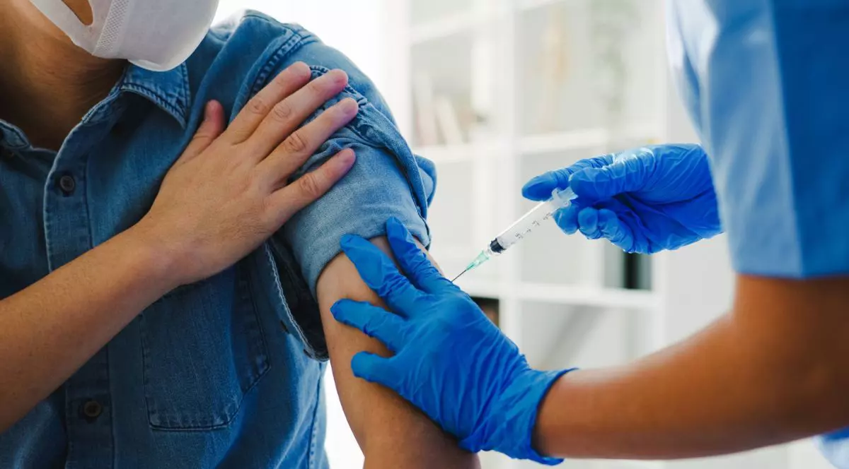 medic care administrează un vaccin în brațul unui pacient