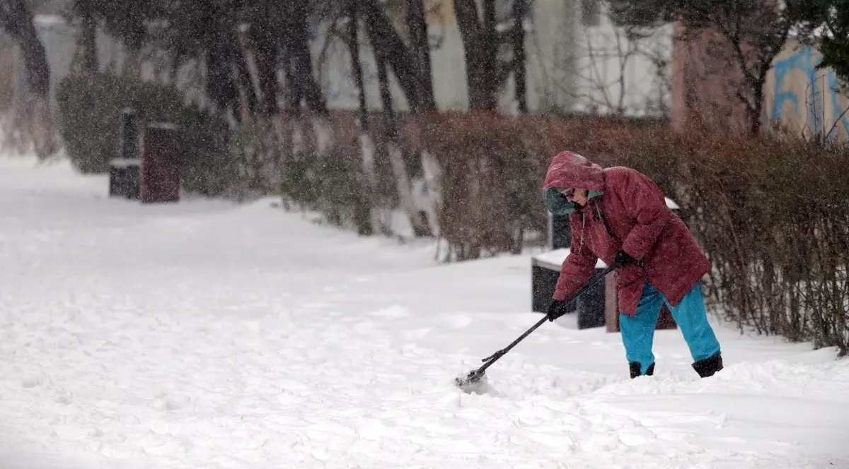 Femeie surprinsă în timp ce dă zăpada.