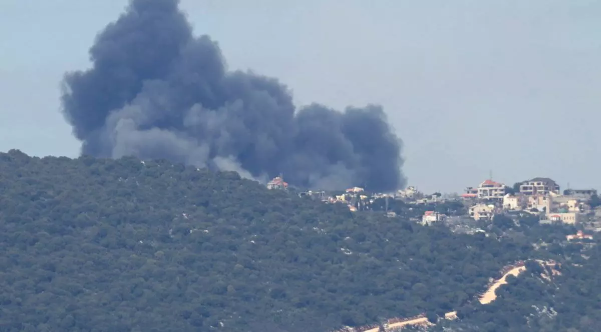 imagine cu un oras micut peste un deal de padure, se observa fum negru in urma unui atac