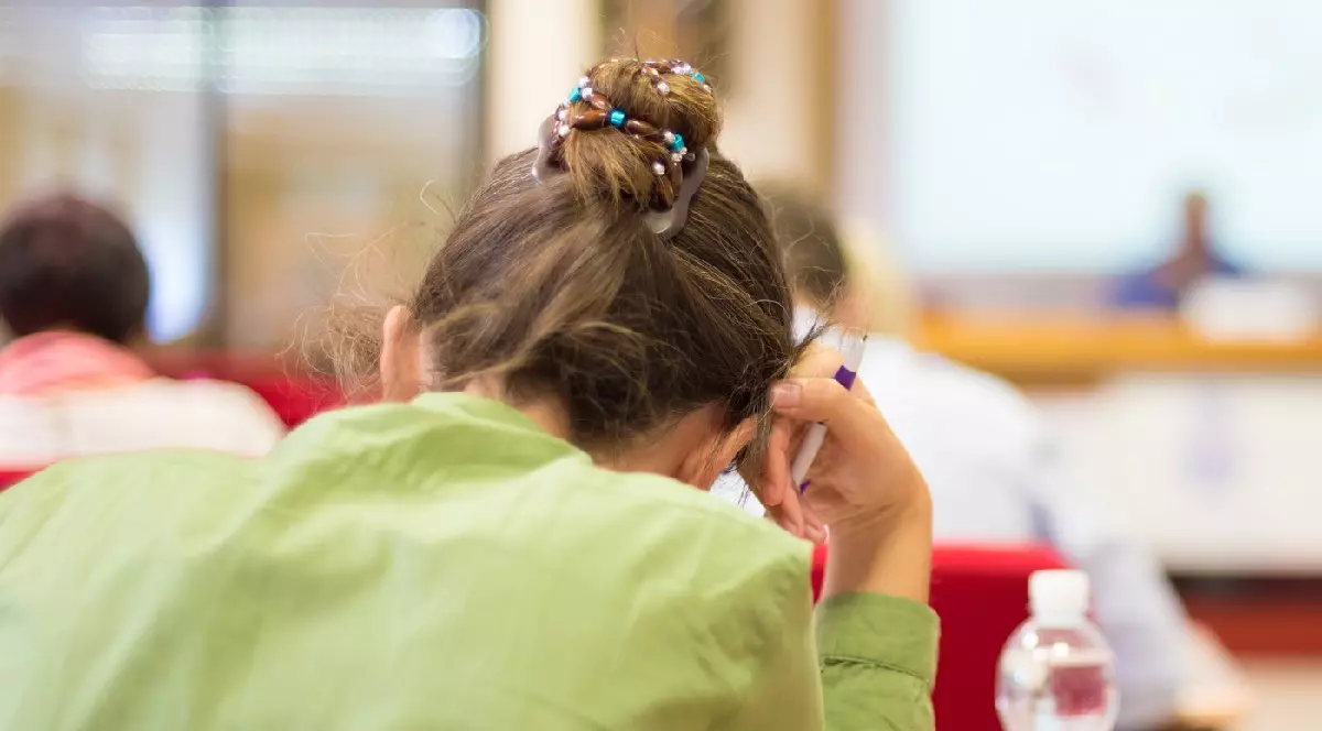 Elevă care scrie examenul final de educație