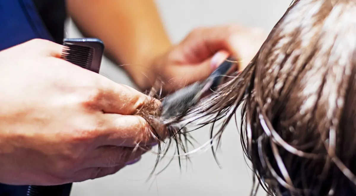 Frizer surprins în timp ce tunde părul unui copil