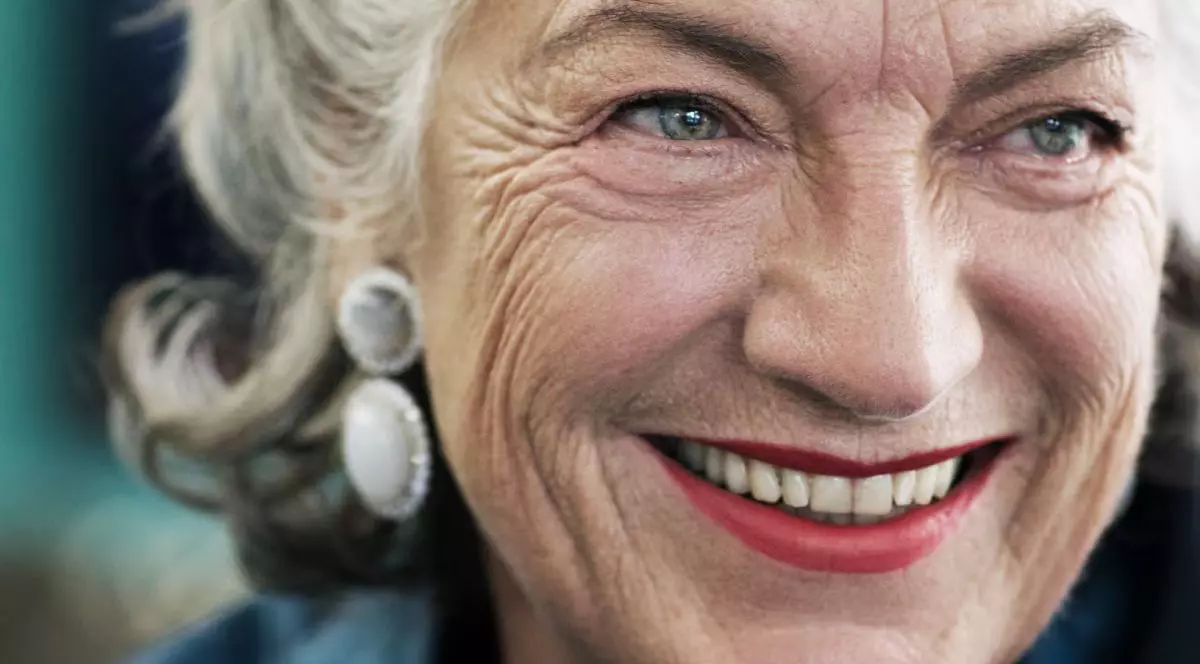 Ellen Ringier, în prim plan, în timp ce zâmbește, cu părul alb și cercei de culoarea perlei