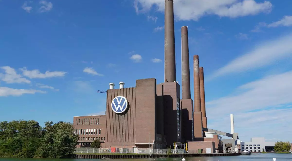 fabrica de producție a sediului Volkswagen din Wolfsburg cu docul și canalul în prim plan și logo-ul mare Volkswagen pe fațada fabricii