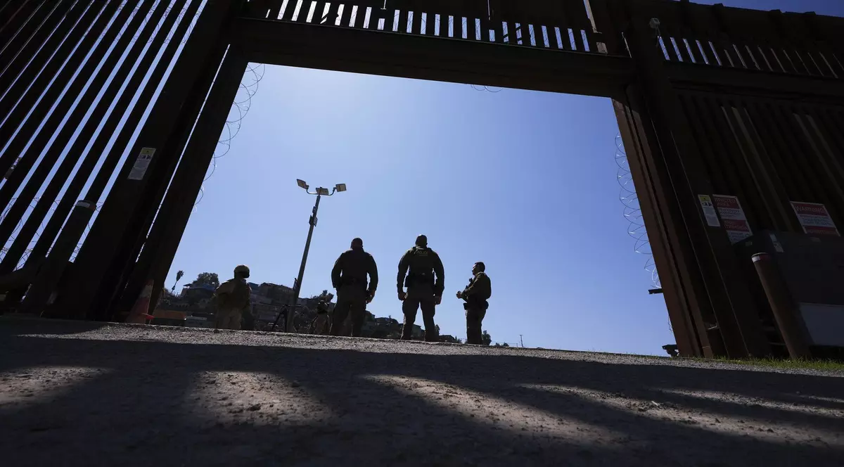 Agenți de poliție surprinși în interiorul unei porți a unuia dintre cele două ziduri de frontieră care separă Mexicul de Statele Unite