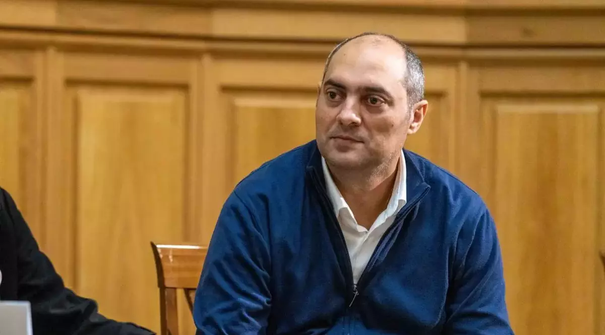 Gelu Duminică îmbrăcat într-un pulover albastru și cămașă albă