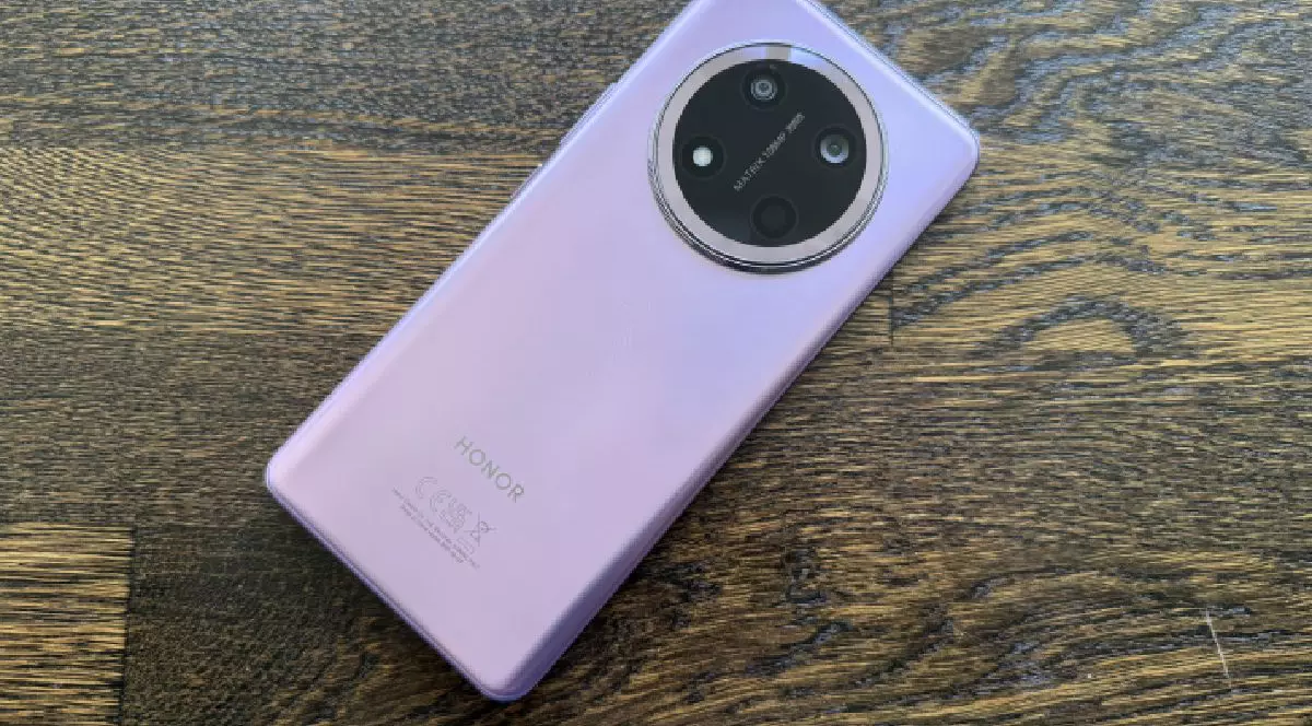 Spatele lila al unui telefon Honor Magic7 Lite pe fundal de lemn.