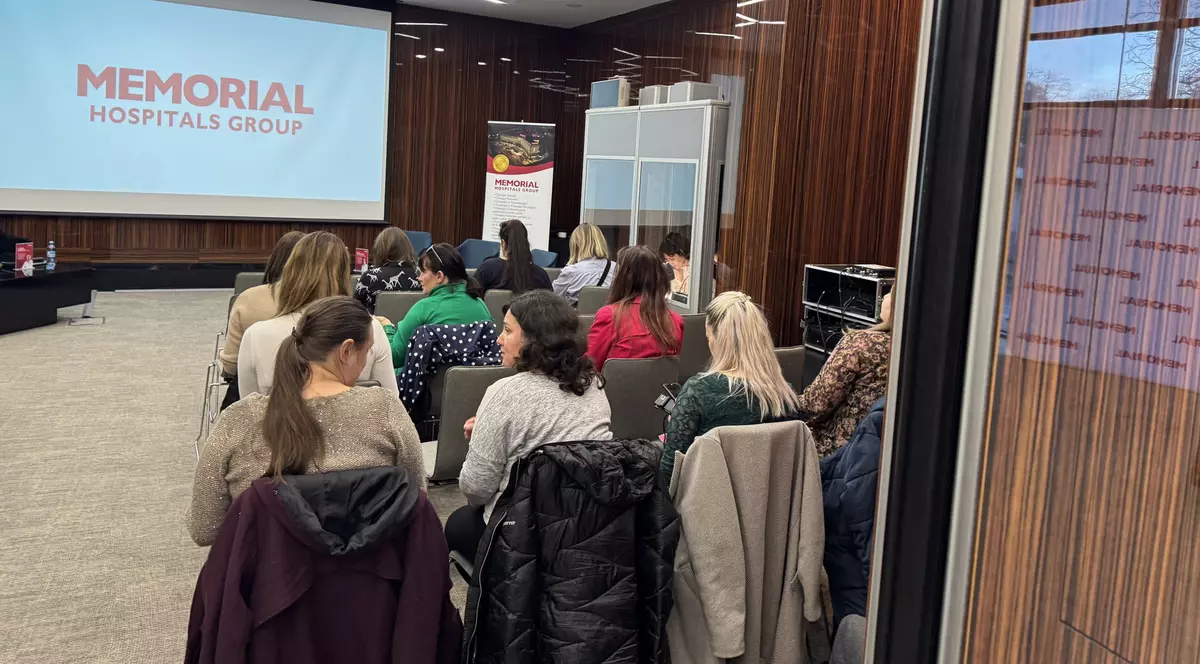 spital Memorial - poza de la o conferinta, unde mai multi oameni stau jos uitandu-se la prezentarea de pe ecran