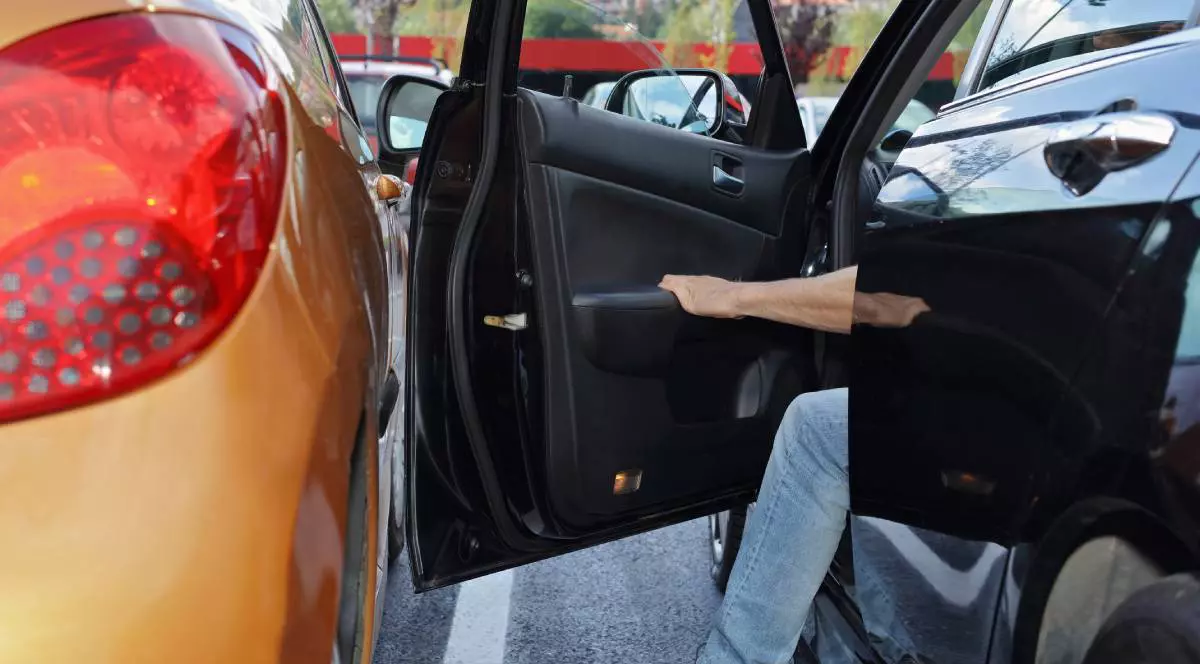 doua masini parcate una langa alta, din masina din dreapta iese un sofer, iar portiera se apropie mult de masina de langa