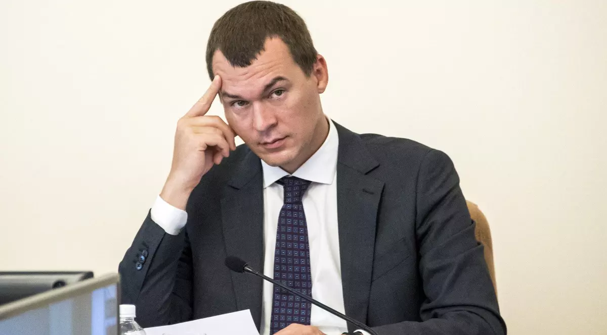 Mihail Degteariov surprins în timp ce-și duce una dintre mâini la frunte. Este îmbrăcat într-un costum negru, cu cămașă albă și are o cravată cu model