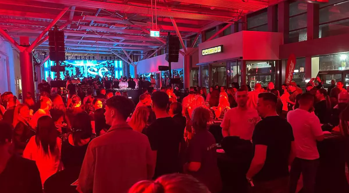 Petrecere aeroport Sibiu, oameni mulți înghesuiți, dansează într-o lumină roșie, Foto: Turnul Sfatului