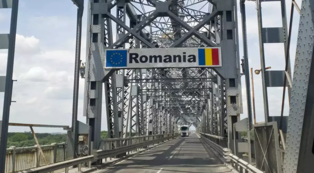 Podul Giurgiu-Ruse, un pod metalic cu o structură de oțel, pe care se află un semn cu inscripția „Romania” alături de steagul Uniunii Europene și steagul României