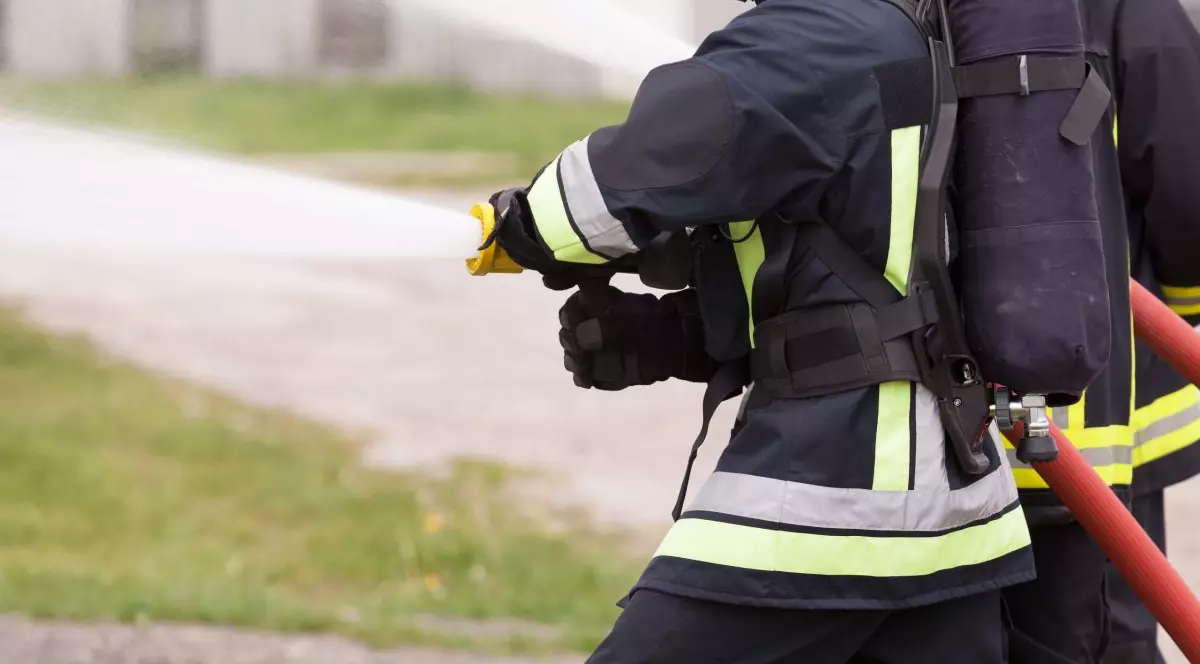 Pompier folosind un furtun cu apă