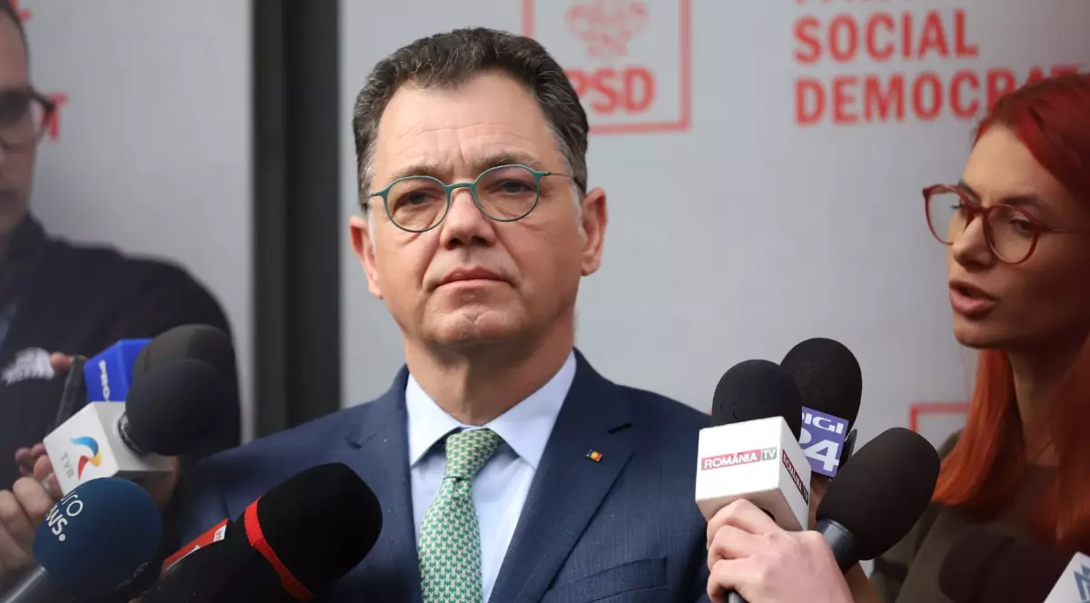 Bărbat îmbrăcat în costum în timp ce acordă un interviu