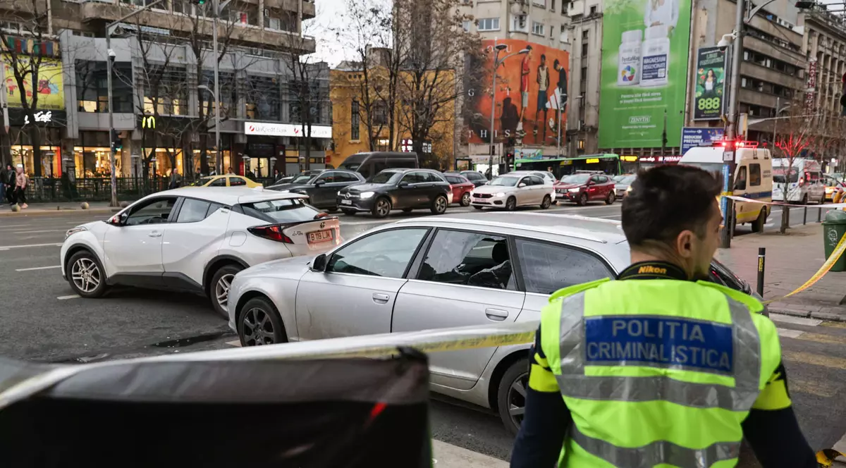 Polițiști de la Criminalistică lângă un audi gri în care un șofer a făcut infarct la volan.