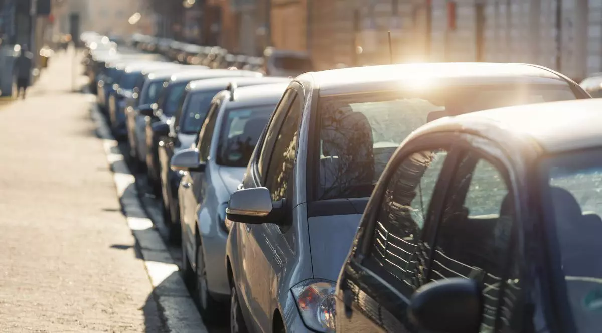 mai multe masini parcate in linie, langa un trotuar