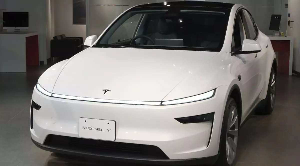 O mașină albă Tesla, Model Y, expusă la un salon auto din Japonia