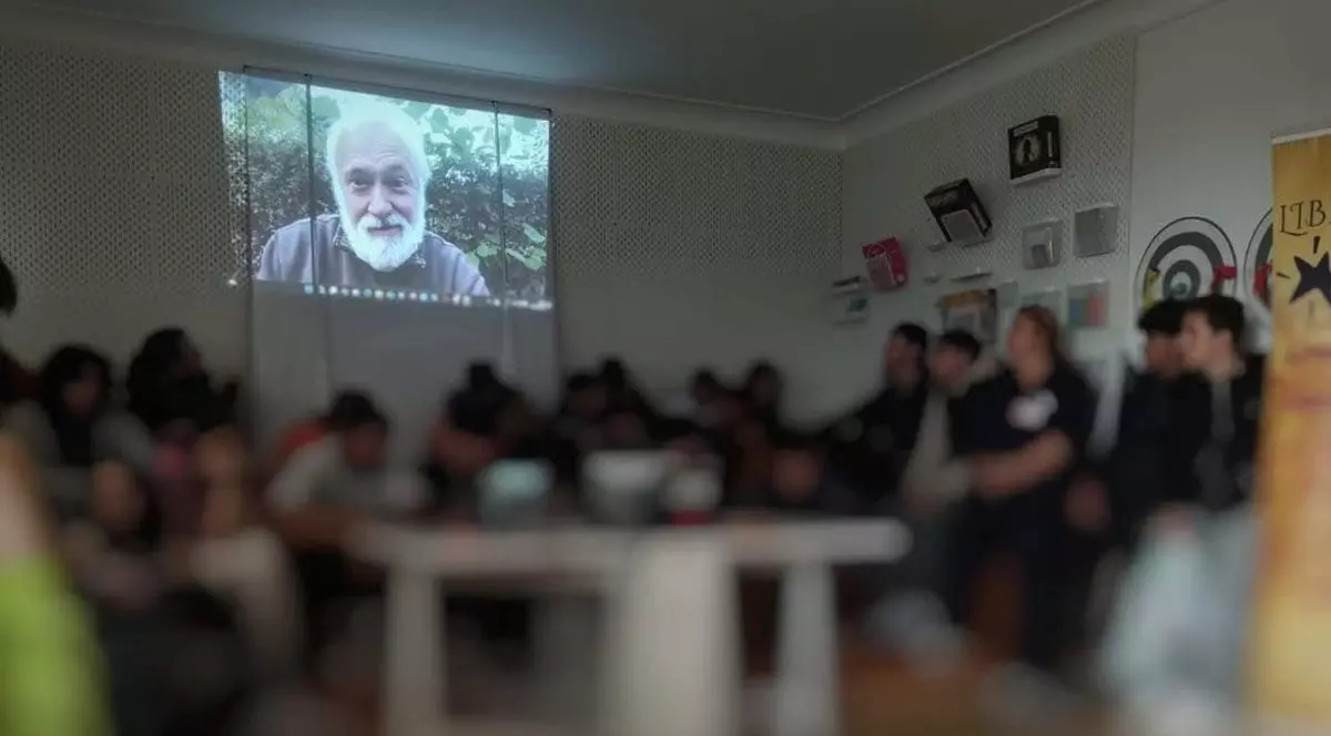 Mai mulți tineri cu fața blurată se află într-o sală cu televizor, la centrul antidrog