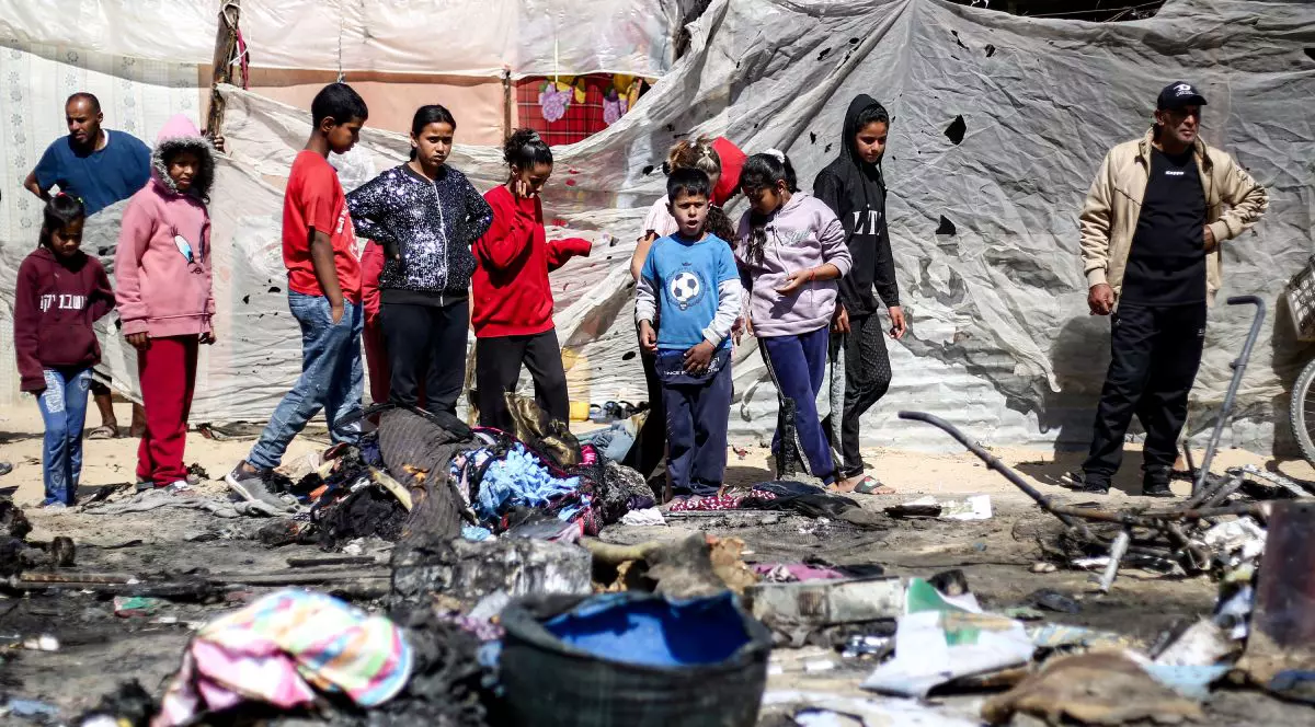 Copiii se adună lângă rămășițele unui adăpost de corturi care ar fi fost lovit de un atac israelian în Khan Yunis, în sudul Fâșiei Gaza, pe 17 aprilie 2025