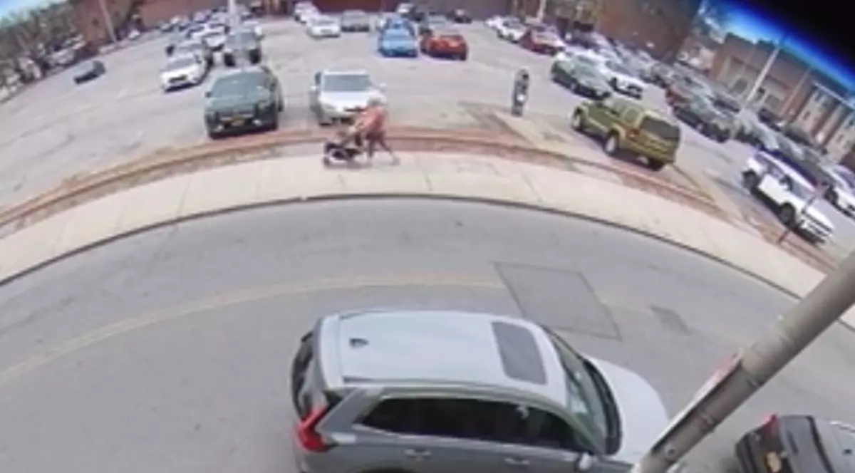 Imaginea este surprinsă de camera de supraveghere. Aceasta ilustrează o femeie pe stradă și mașini