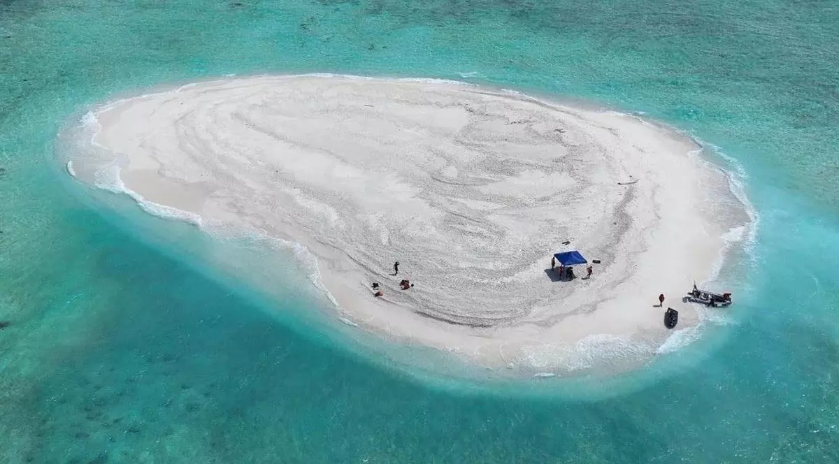 Imaginea, primită de la Garda de Coastă Filipineză și Biroul pentru Pescuit și Resurse Acvatice, prezintă o vedere aeriană a oamenilor de știință filipinezi care inspectează reciful Sandy Cay, în apropierea insulei Thitu, deținută de Filipine, în Insulele Spratly, în apele disputate ale Mării Chinei de Sud, 21 martie 2024.