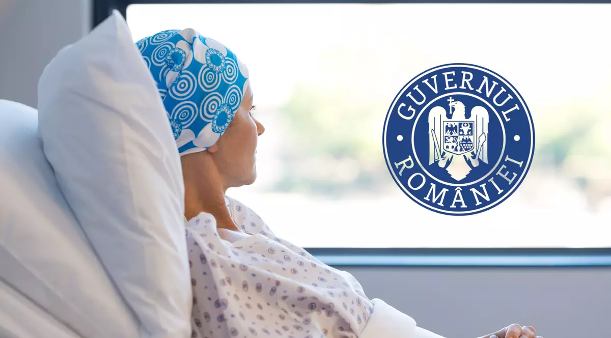 in poza se observa o femeie care sta pe un pat de spital langa geam. ea poarta o boneta albastra pe cap si un halat alb de spital cu floricele