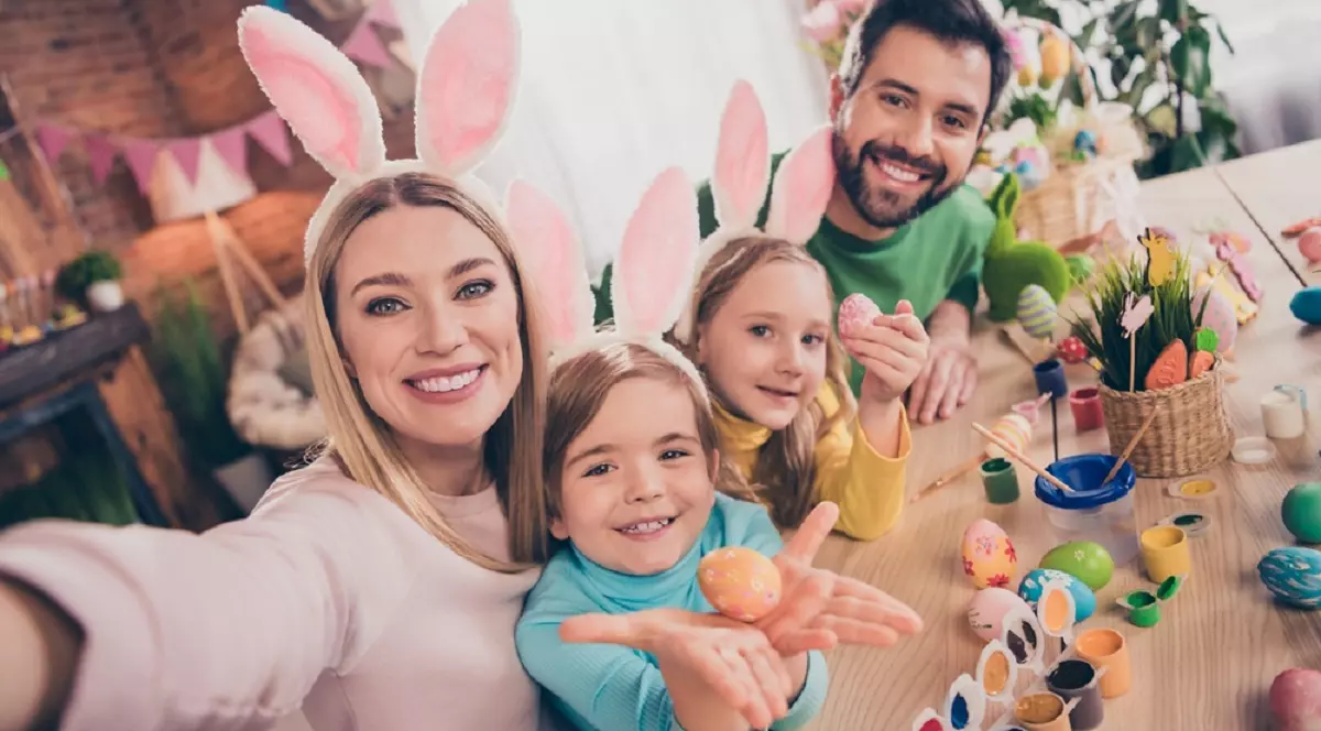 Vacanţa de Paşte 2025 – Când începe şi cât durează - Imagine cu o familie, formată din mamă, tată şi două fetiţe, costumată în iepuraş de Paşte