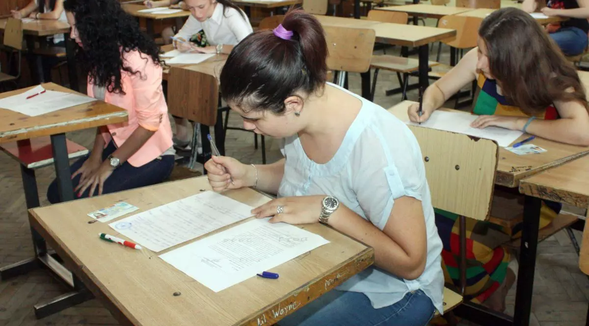 Elevi în bănci care susțin examenul de Bacalaureat