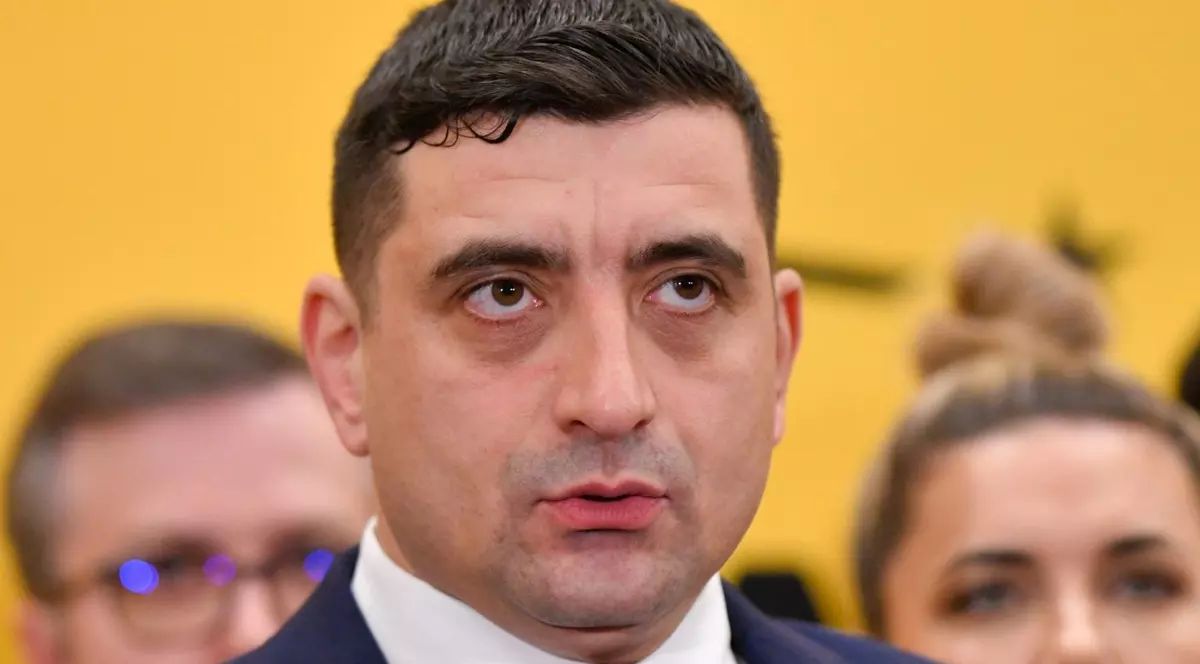 George Simion, președintele AUR, la un eveniment, având în spate un fundal portocaliu