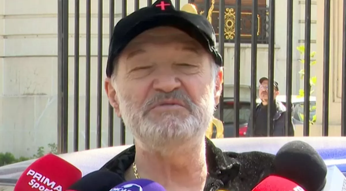 Gigi Becali dă declarații în fața palatului său din Aleea Alexandru, are mai multe microfoane de la diverse televiziuni și publicații în față.