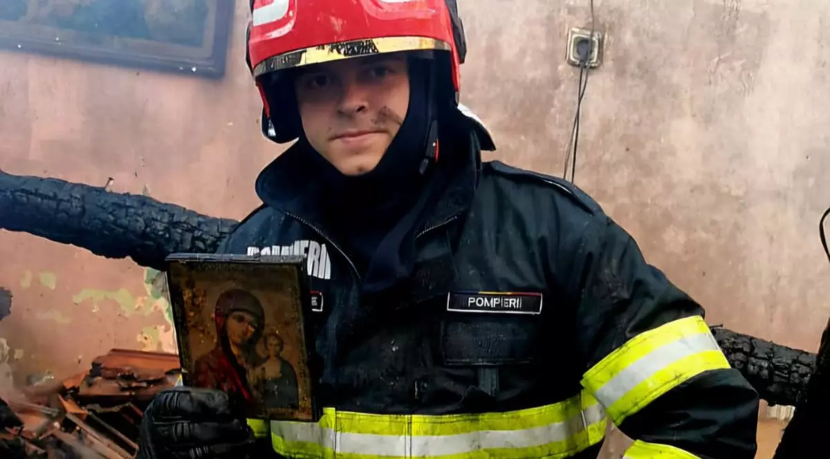 Icoana rămasă neatinsă după un incendiu violent din Brașov, ținută în mână de um pomier, aflat în mijlocul unei camere acoperite de funingine