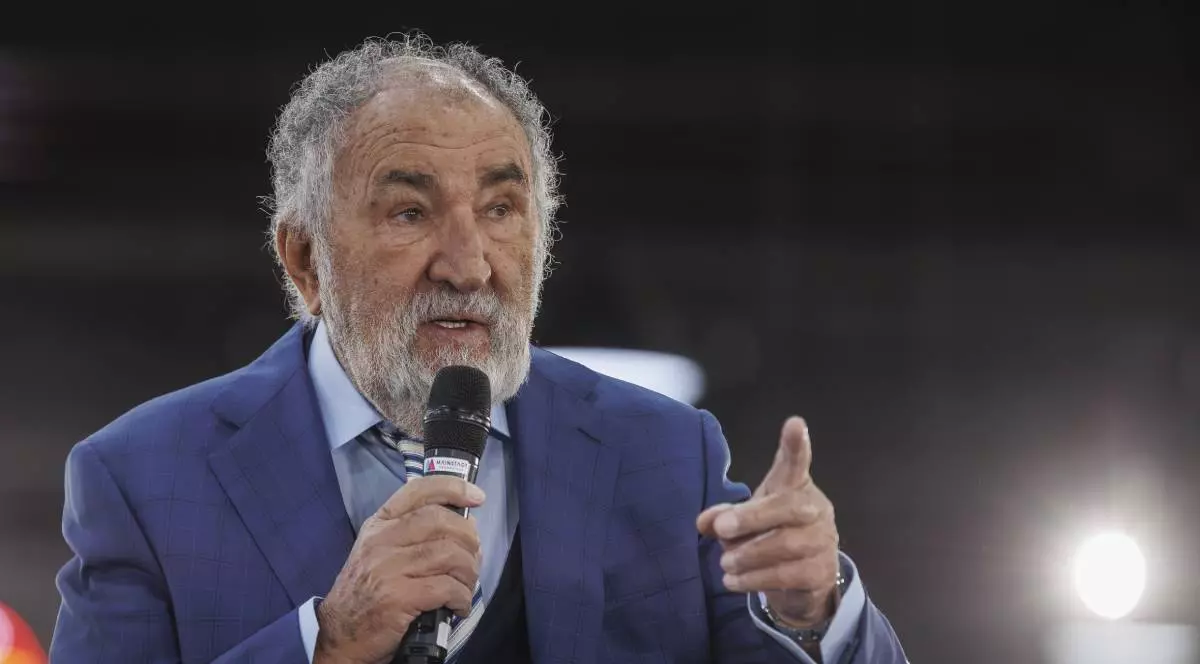 ion tiriac imbracat intr-un sacou albastru in timpul unei conferinte vorbind la un microfon