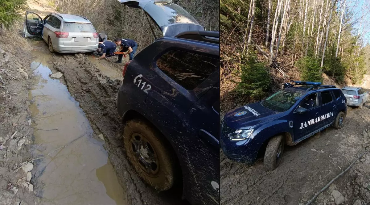 o masina argintie blocată în noroi pe care doi jandarmi încearcă să o deblocheze, alături este și mașina jandarmeriei