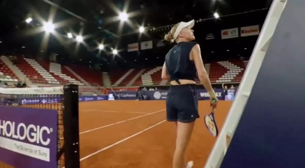 jucatoare de tenis aflata pe teren in timp ce vorbeste cu arbitrul